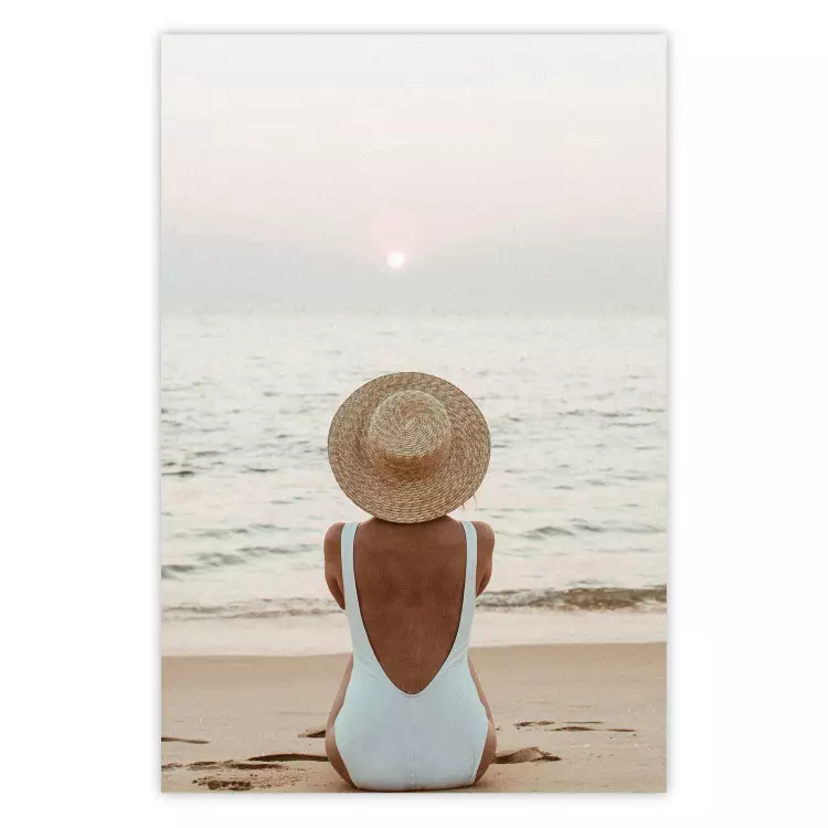 Strandpause - Frau sitzt im Sand mit Sonnenuntergang im Hintergrund