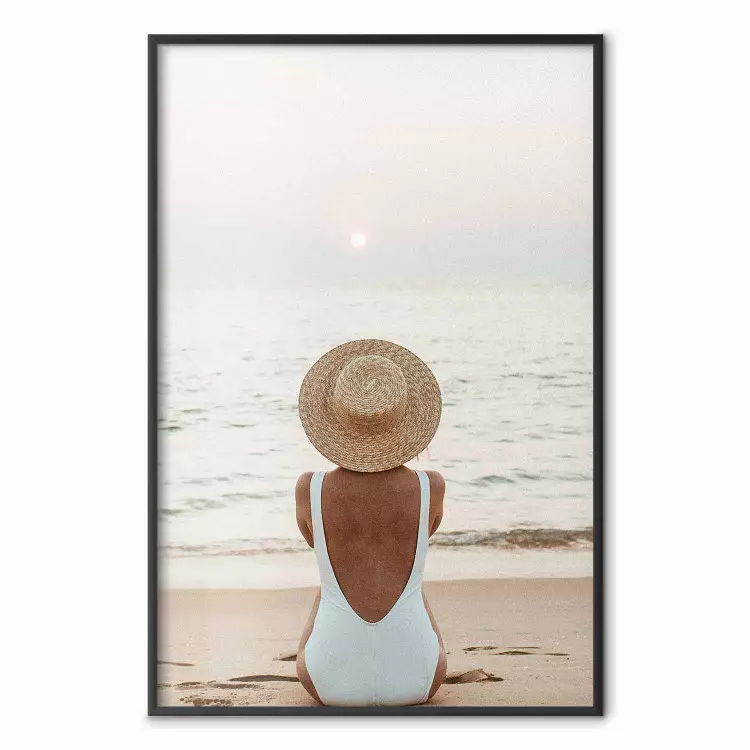 Strandpause - Frau sitzt im Sand mit Sonnenuntergang im Hintergrund
